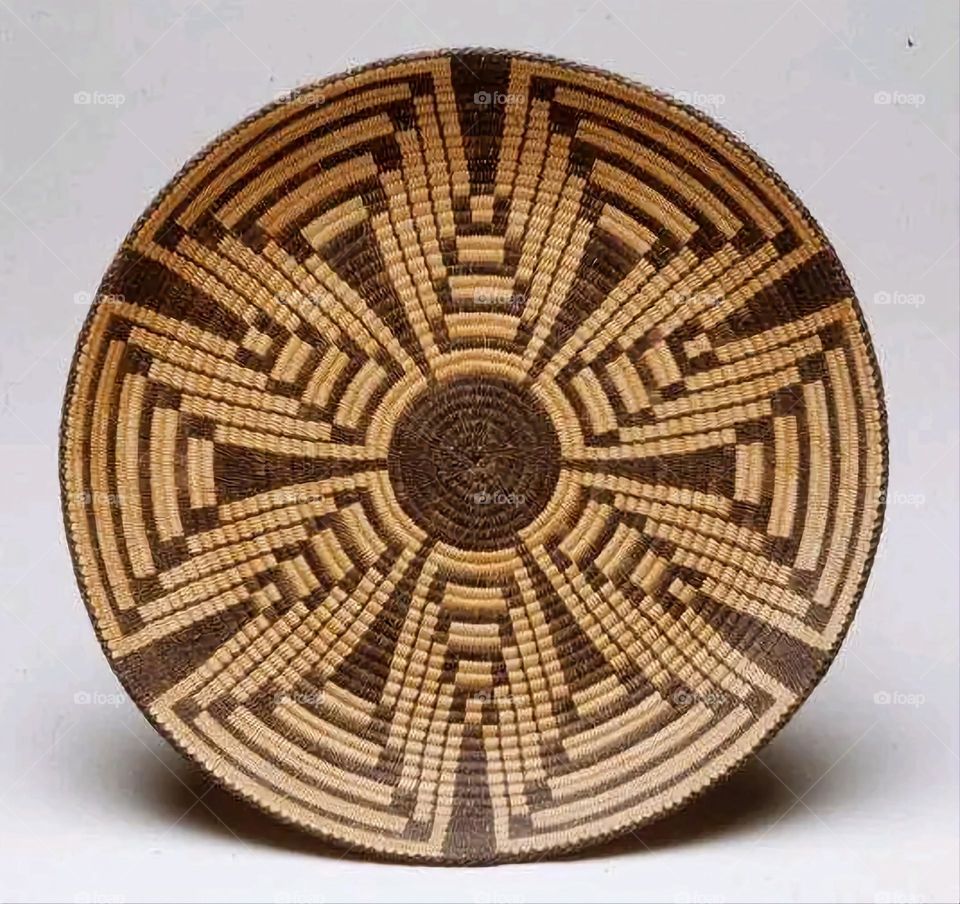 The image shows a group of hand -made dishes of wicker, decorated with colored embroideries with beautiful floral shapes, and is elegantly displayed in a warm corner that combines heritage and beauty, which gives the place an artistic spirit and attr