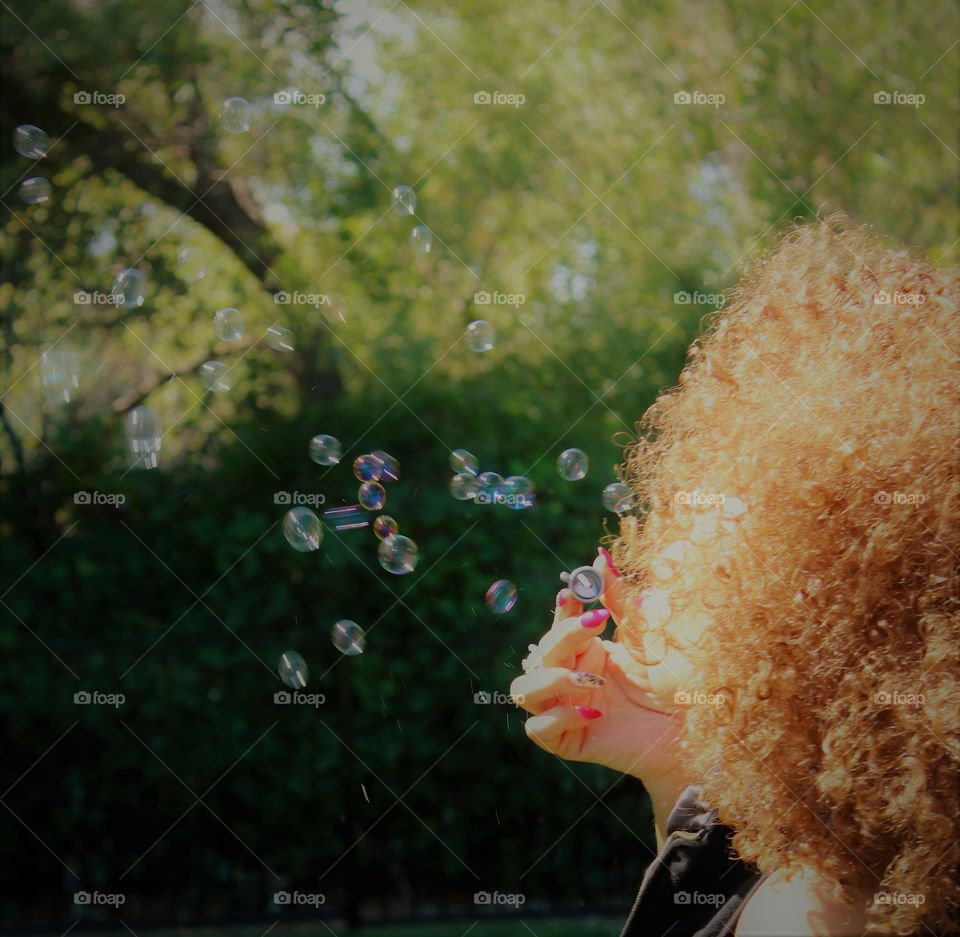 blowing bubbles in the park on a sunny day
