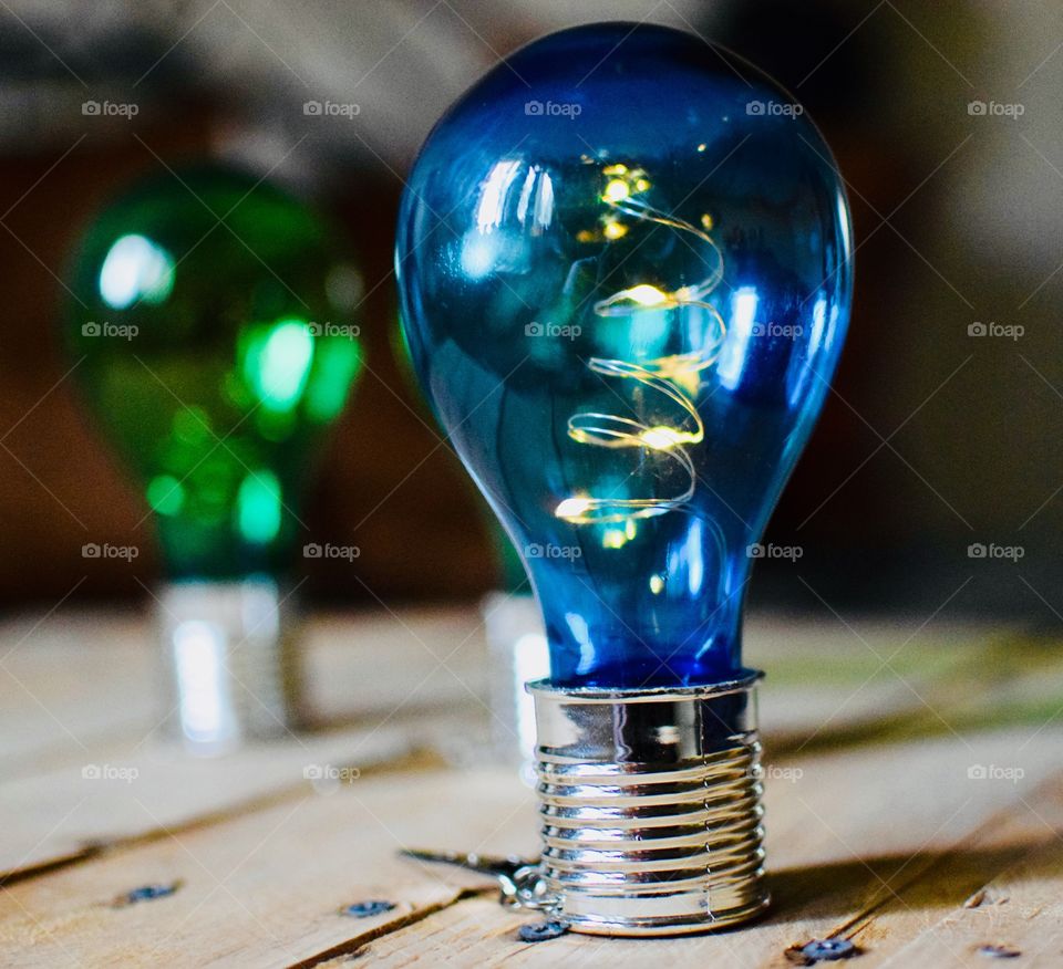 Blue and green solar light bulbs on a wooden display 