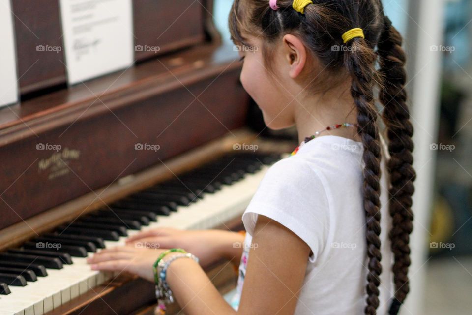 Cute girl is playing piano