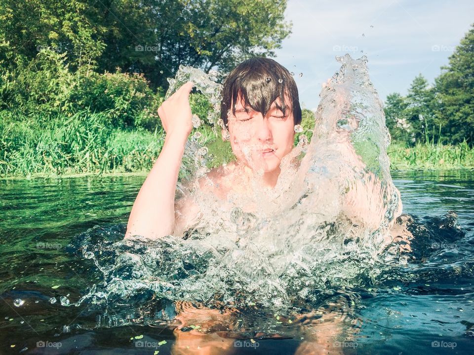 Boy splashing water on his face