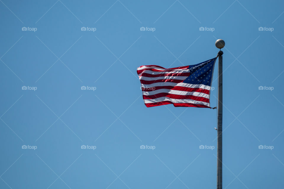 United States of America flag in clear blue sky background 