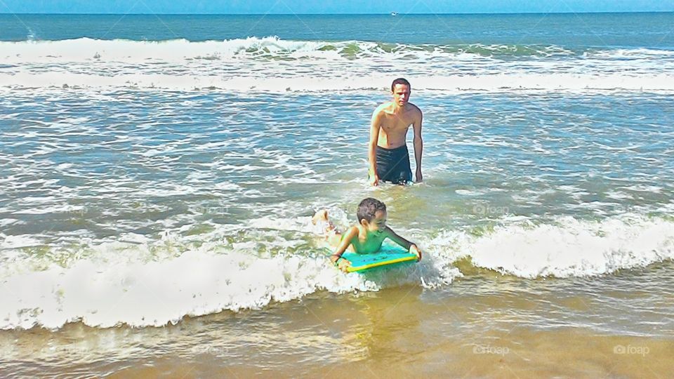 Father and son surfing at beach