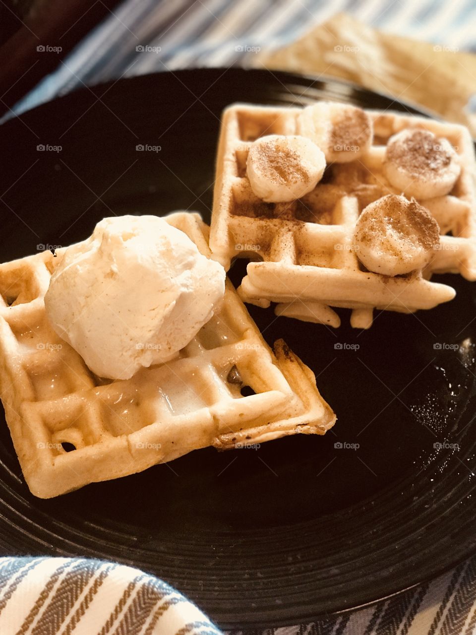 A delicious breakfast of waffles with bananas and vanilla ice cream and cinnamon on top. USA, America 