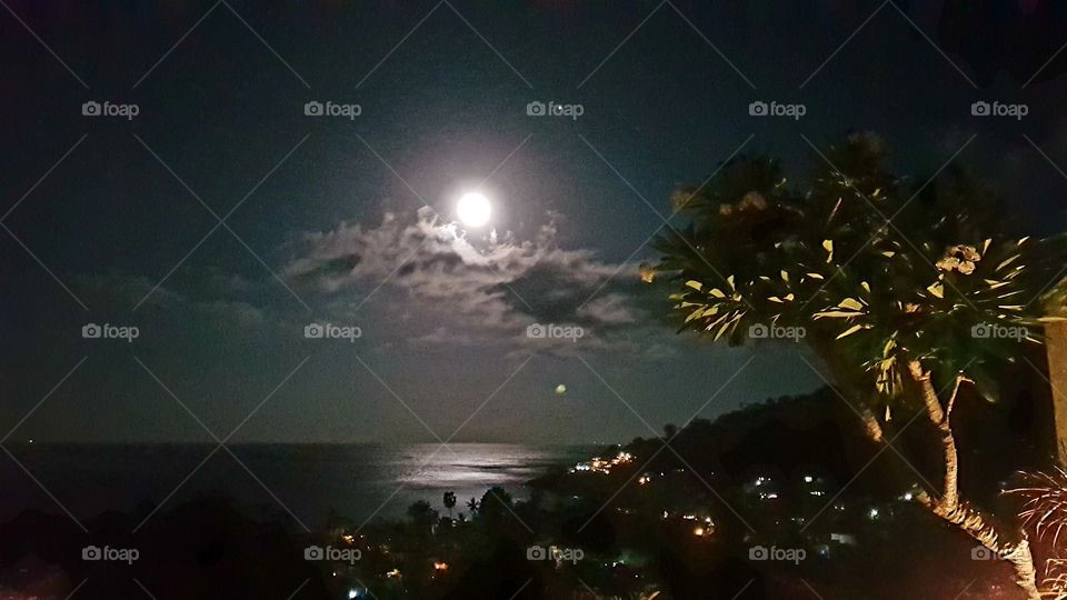 The moon is reflected on the sea off east Bali in Indonesia
