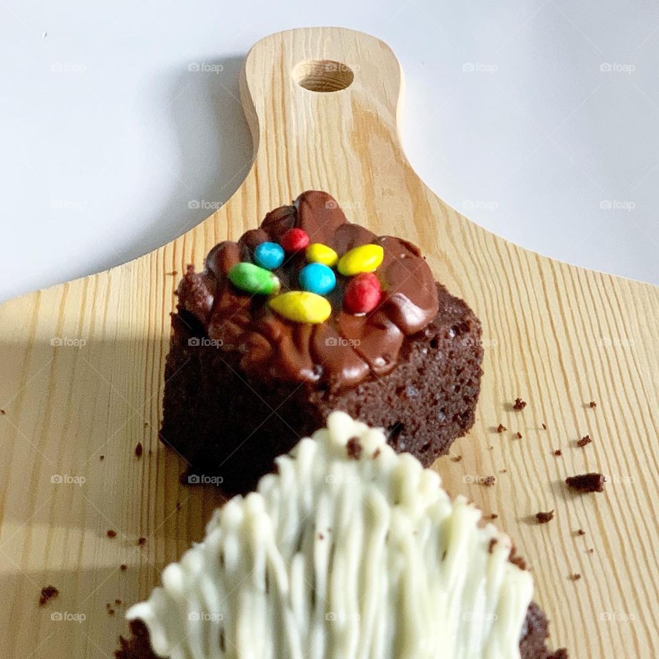 Home baked brownies in white chocolate drizzle and M&Ms sprinkles 