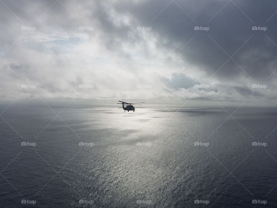 S70 type helicopter flying over the Pacific Ocean.