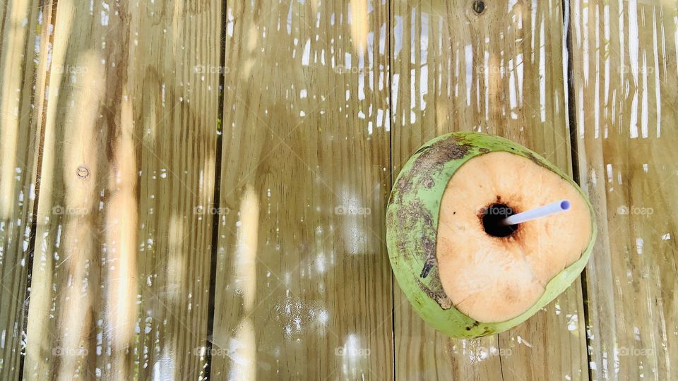 coconut water drink on the glass table reflecting the wooden roof
