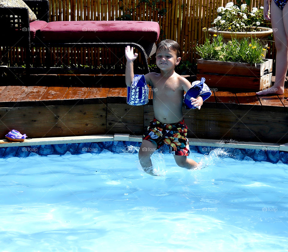 Shirtless boy jumping in swimming pool