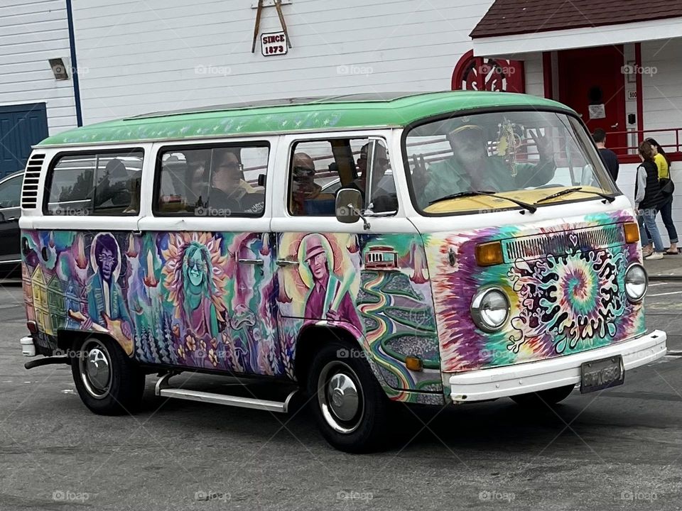 A 1960s psychedelic hippie peace loving van makes an appearance in modern day 2024 in San Francisco, California.