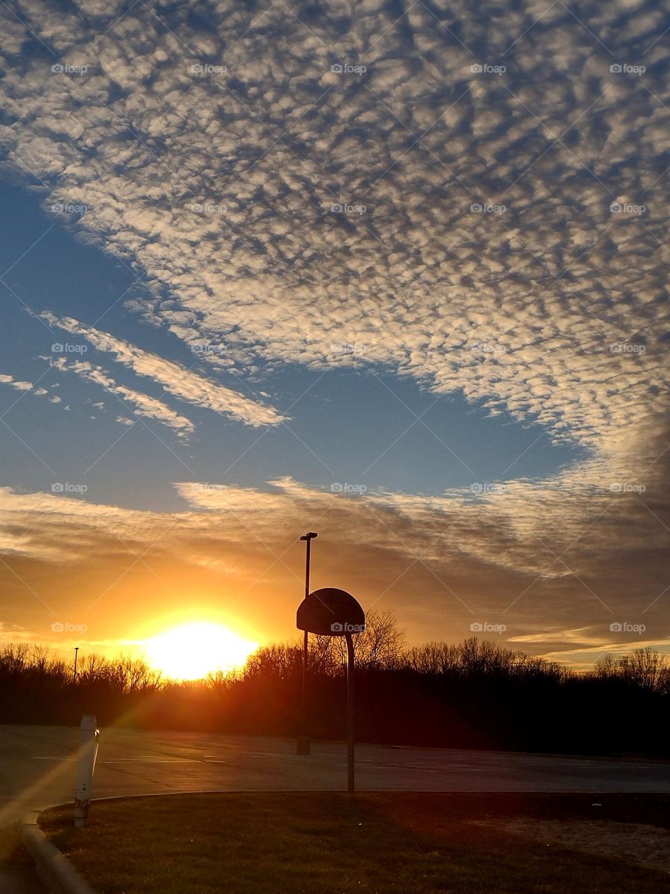 Unfiltered, beautiful, lovely sunset and clouds over a basketball court