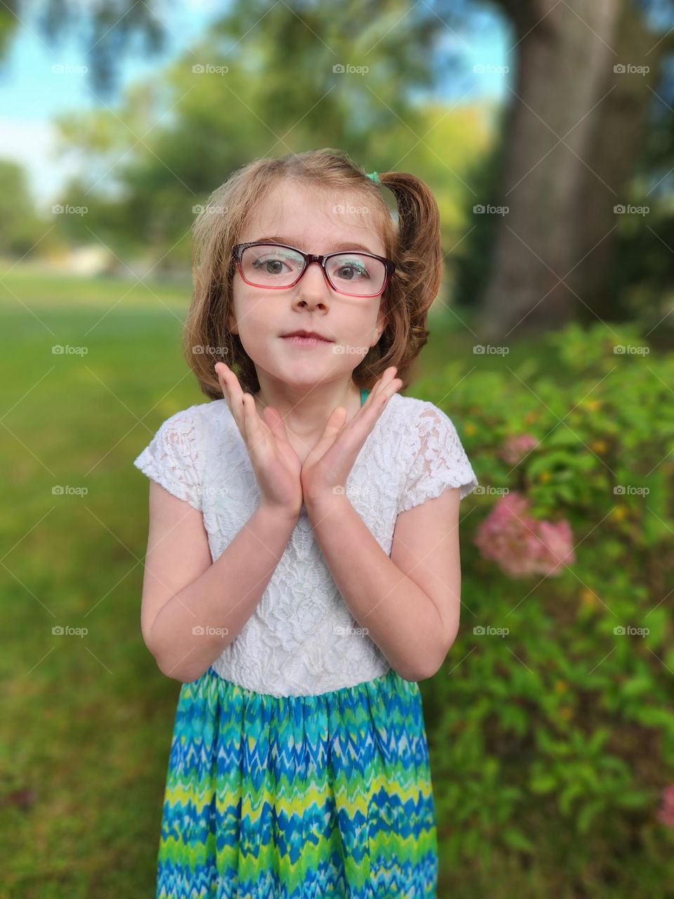 Six year old girl mid clap framing face