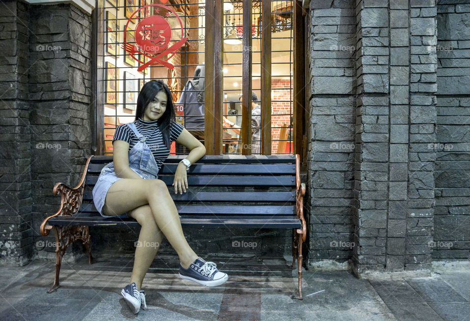 Smiling asian woman sitting on bench