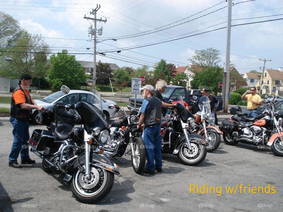 Motorcycles lined up idling. Riders are checking them out before leaving.Hot beautiful sunny day for our ride.