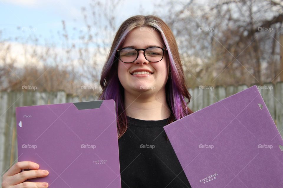 Teenager student with purple five star folder 