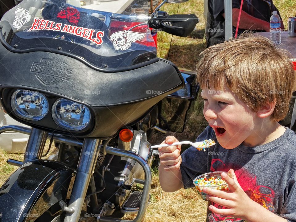 Young Motorcycle Enthusiast. Little Boy At A Motorcycle Biker Gathering
