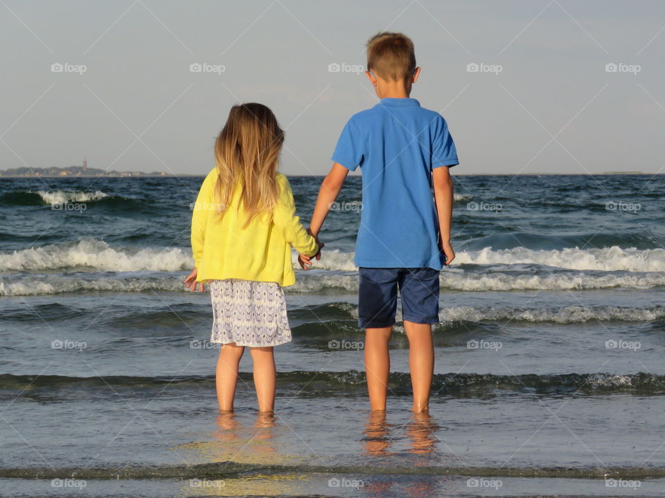 Rear view of a kids standing on beach