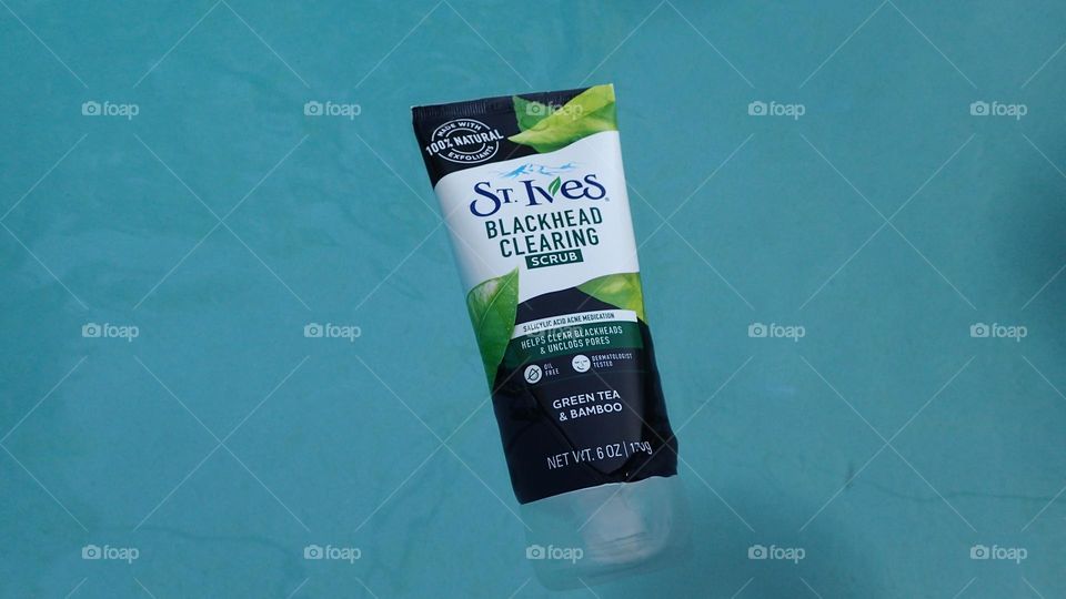 St. Ives beauty product exfoliant bottle floating on bright blue water pool