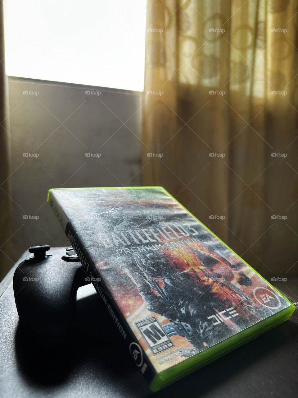 Battlefield video game box above of a Xbox controller with natural light at the background.