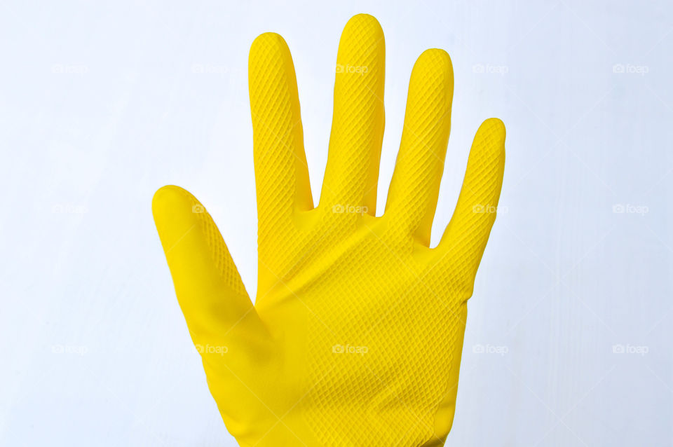 Person's hand wearing a yellow rubber glove