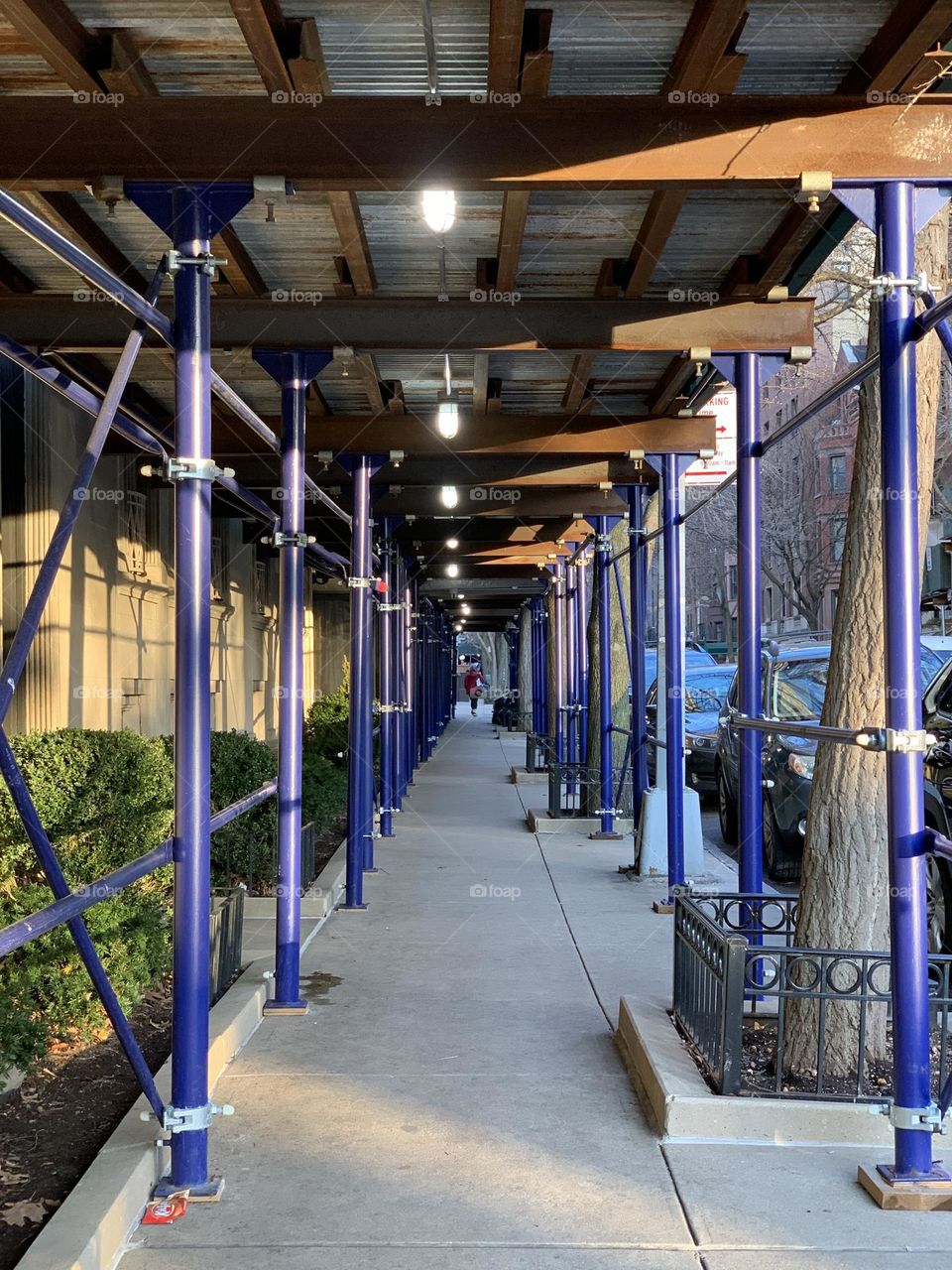 A woman walking under the scaffolding 