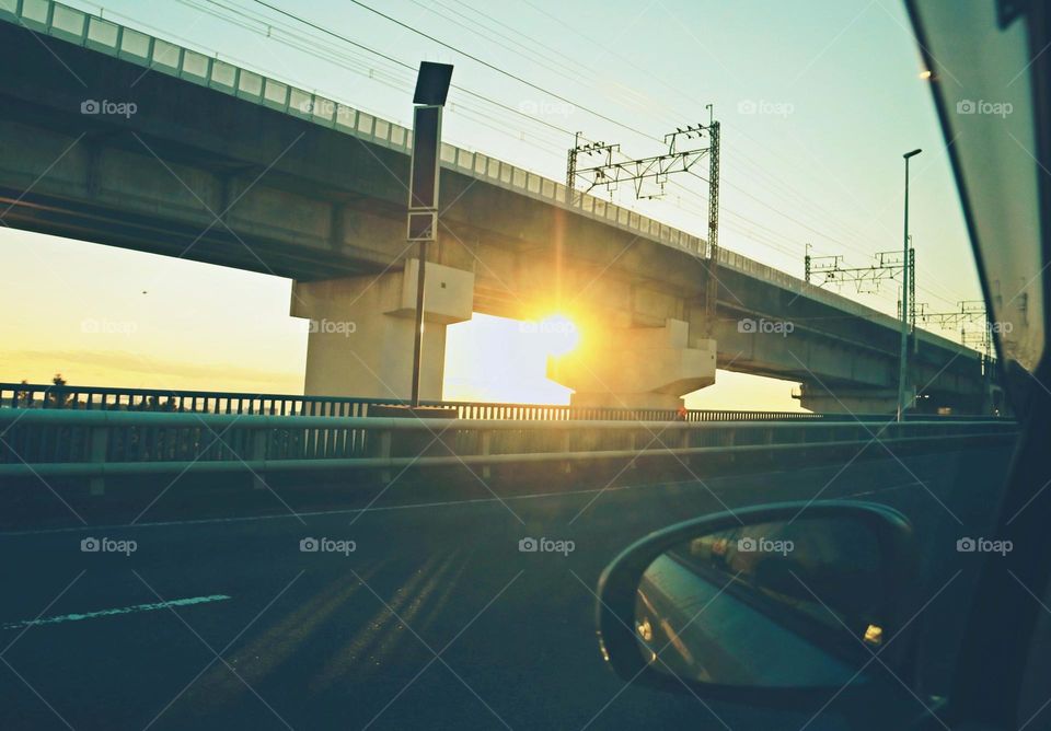 Car side mirror at sunset