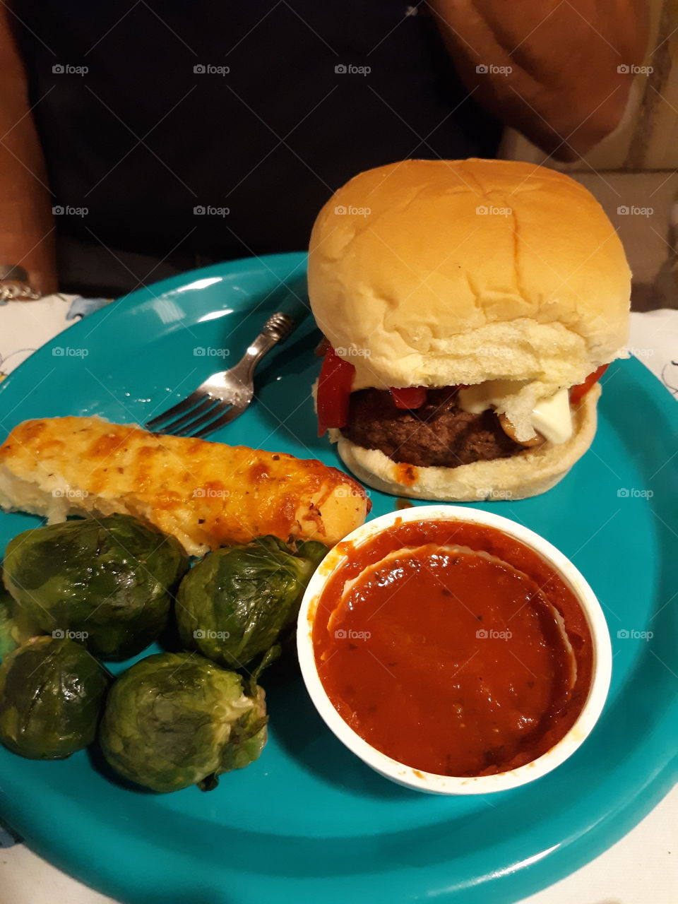 Cheeseburger with roasted red peppers in a Hawaiian roll served with steamed Brussel sprouts and a cheesy breadstick with marinara sauce.