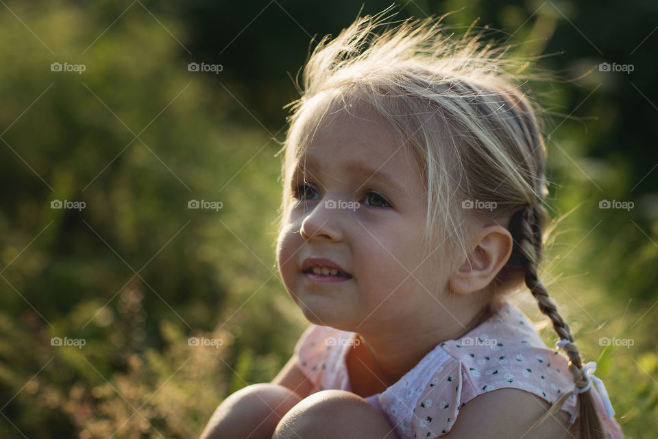 Portrait of cute little girl with blonde hair outdoor 