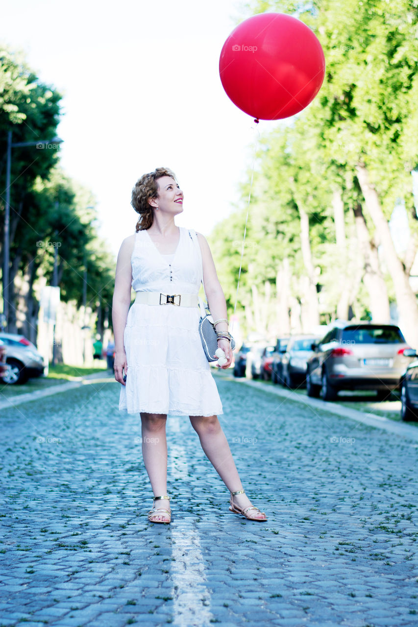 big red ballon. girl with big red ballon on the street