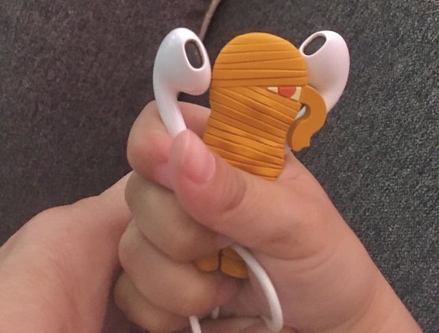 Hand holding earphones and a mummy earphone organiser
