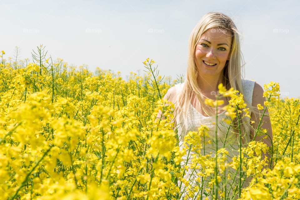 Woman 30 years old walking in a Raps field outside Malmö in Sweden.