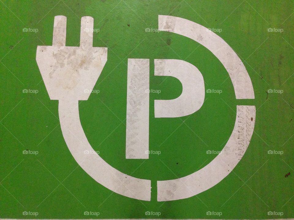 Sign painted on the concrete floor to indicate parking space reserved for electronic cars in a underground parking garage.
