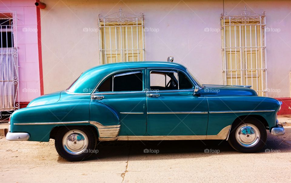 Classic American car in Cuba. Classic American car as taxi parked in the street in front of old buildings in historic Trinidad, Cuba.