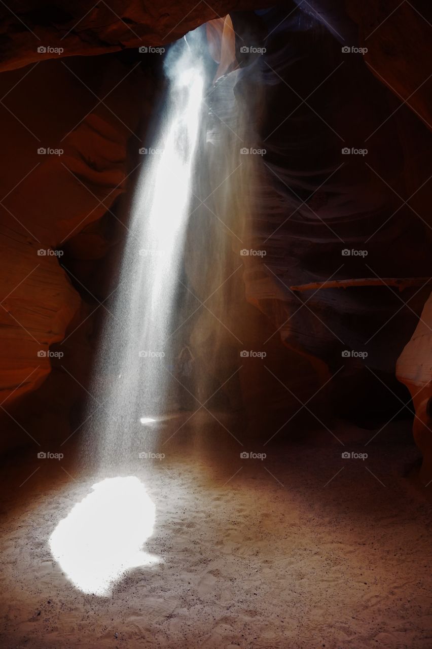 a ray of light in the dark of a canyon with sand inside