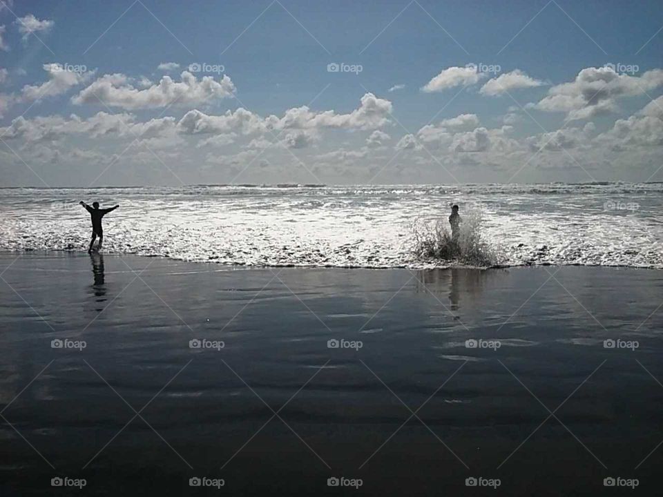 kids playing in waves