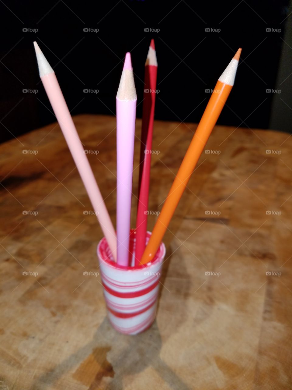#clash of colour - colored pencils in red spiral shot glass, on wood.