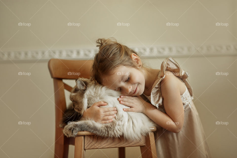 Vintage portrait of a beautiful little girl with rag-doll cat