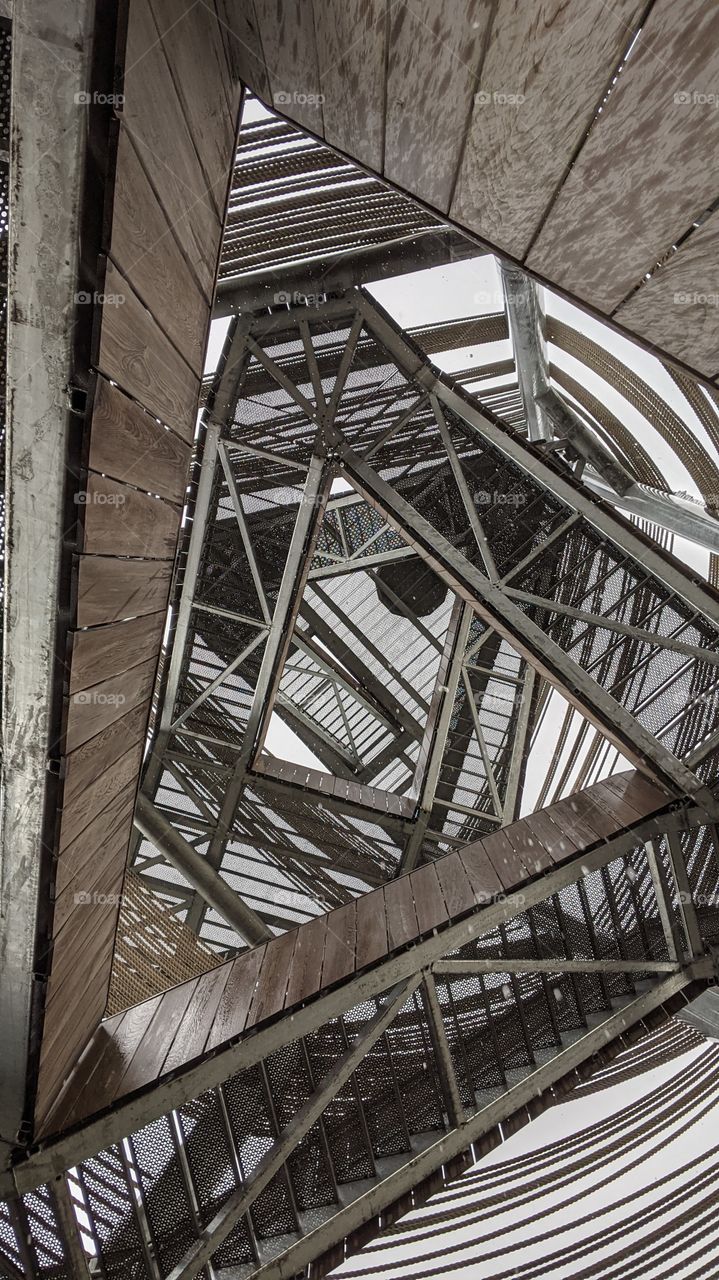 The inside of a climbing tower. The staircase is engulfed with ropes and spirling up into the sky.