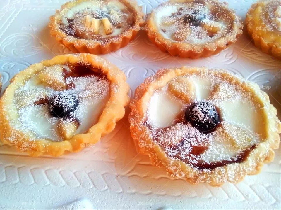 Homemade mini tarts with black cherries and milk cream