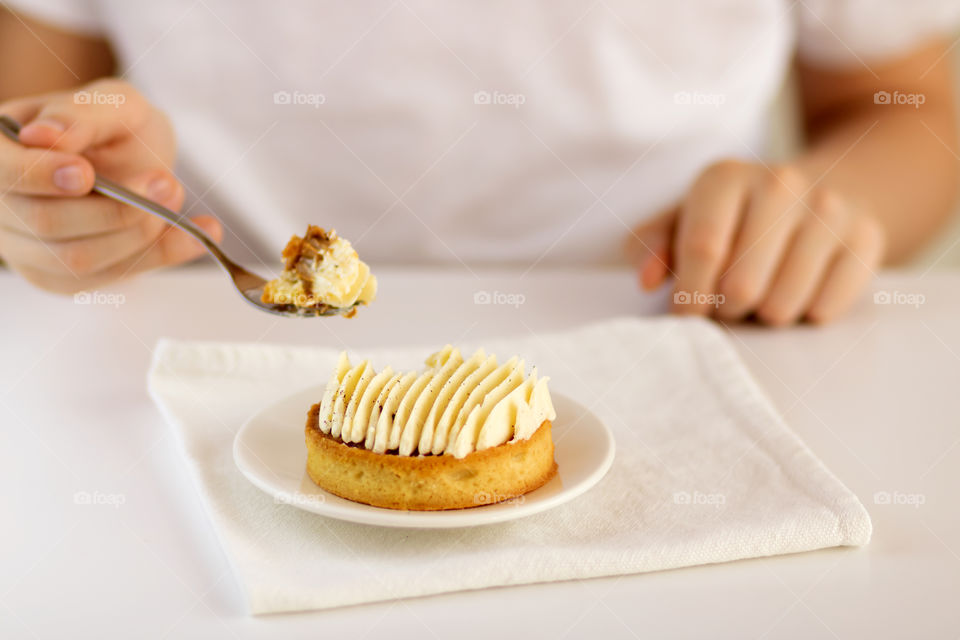 Vanilla cream cake on the white plate on the table.
