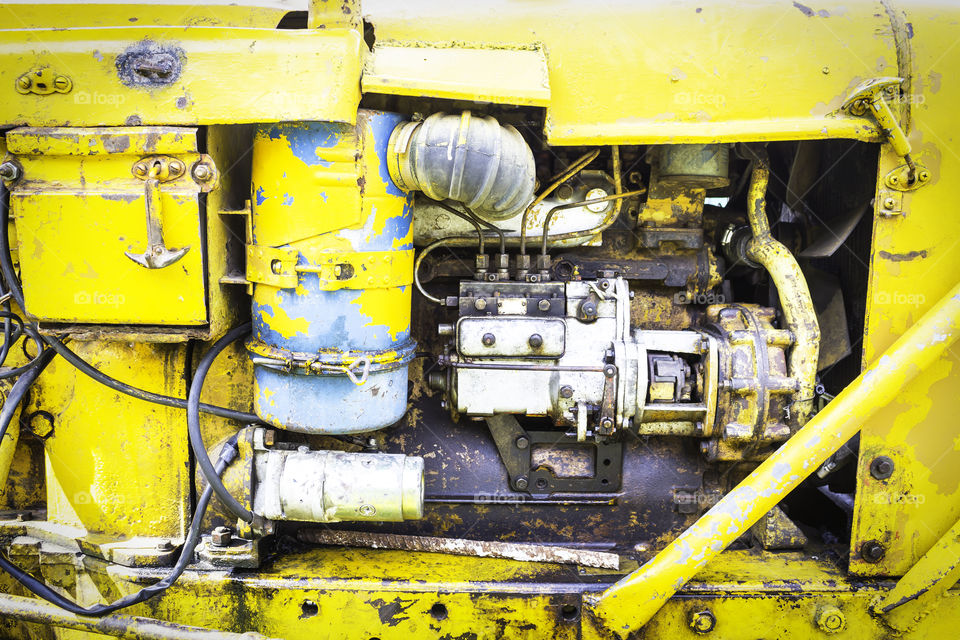 Old engine machine of yellow tractor