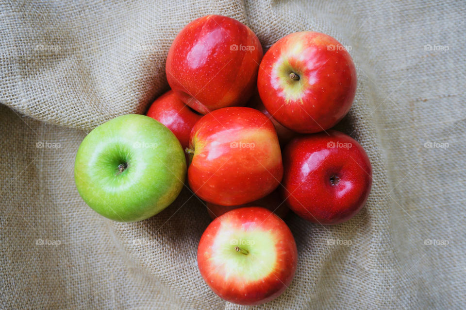 Green and red apples on fabric background 
