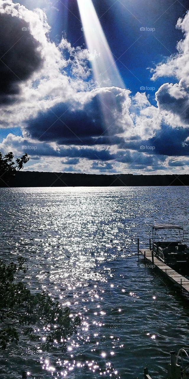 beautiful sun ray penetrating clouds over the water