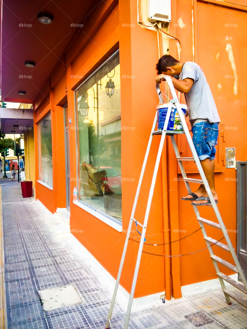 worker painting the exterior of a store