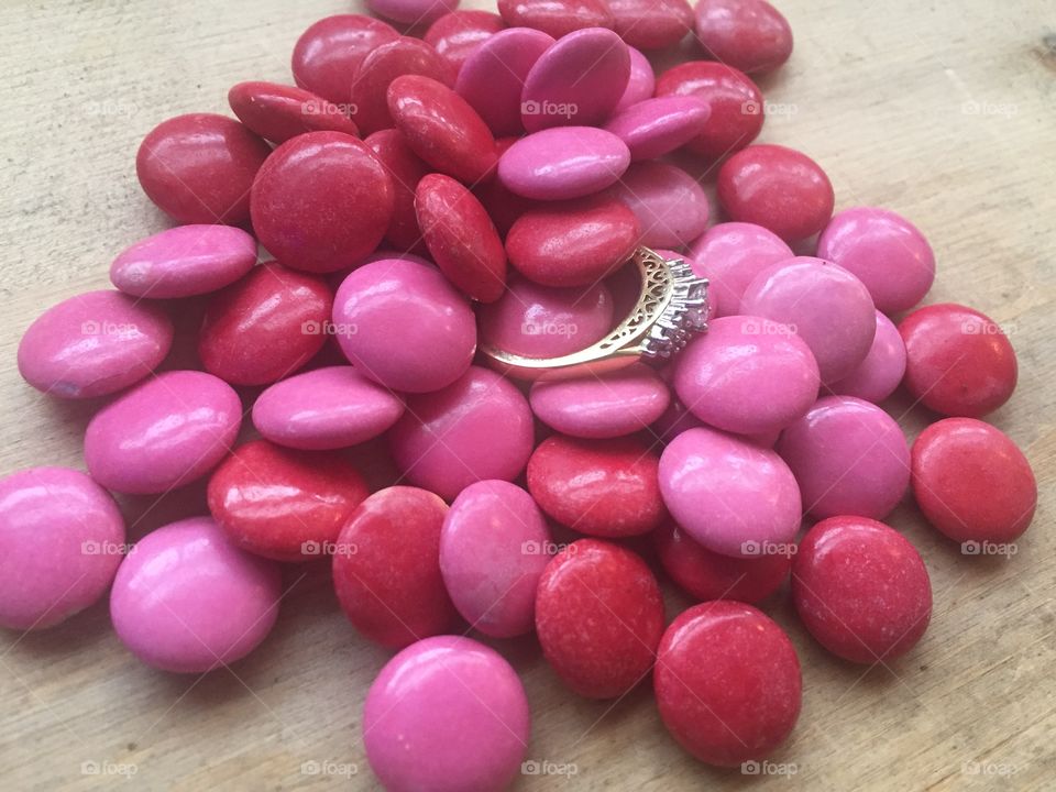 Pink and red candies with wedding engagement ring with hearts love for Valentine's Day 
