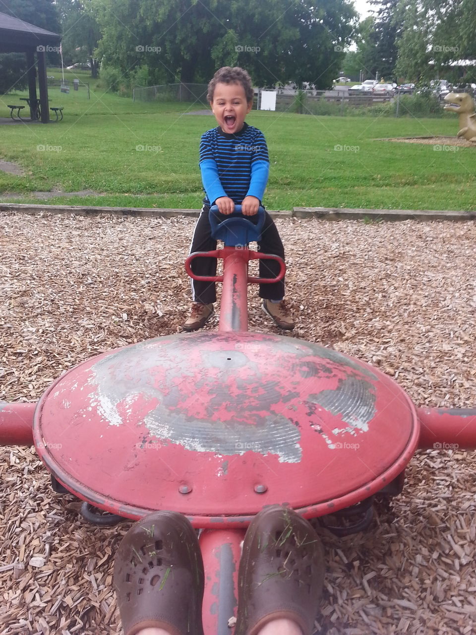At the playground with Grandma. Boy having fun at park with his grandma