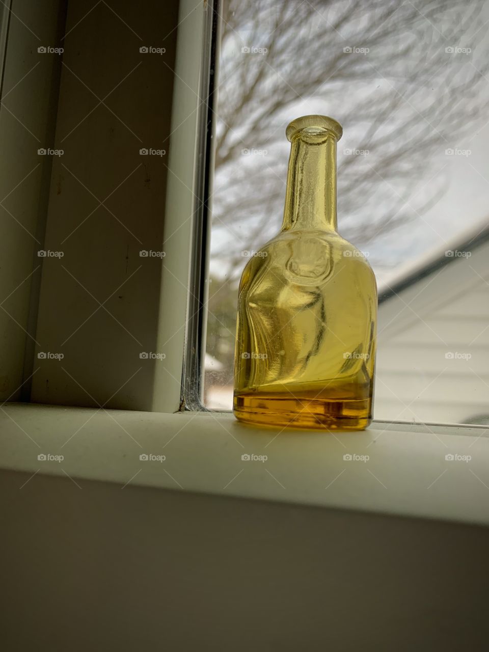 Small glass bottle on windowsill 