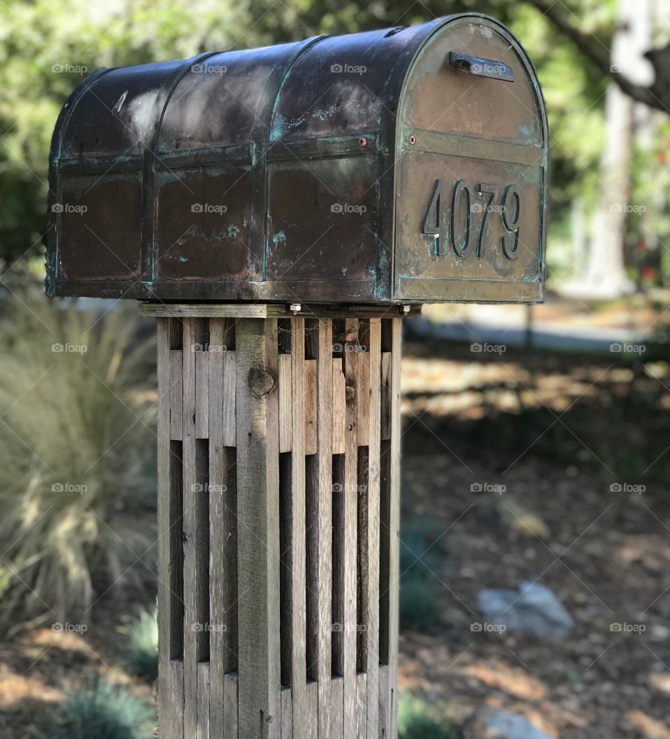 Art and beauty can be found in anything. The intertwining and overlaying of woodwork in something as simple as a mailbox. And the addition of a blueish green patina speckling the metal. 