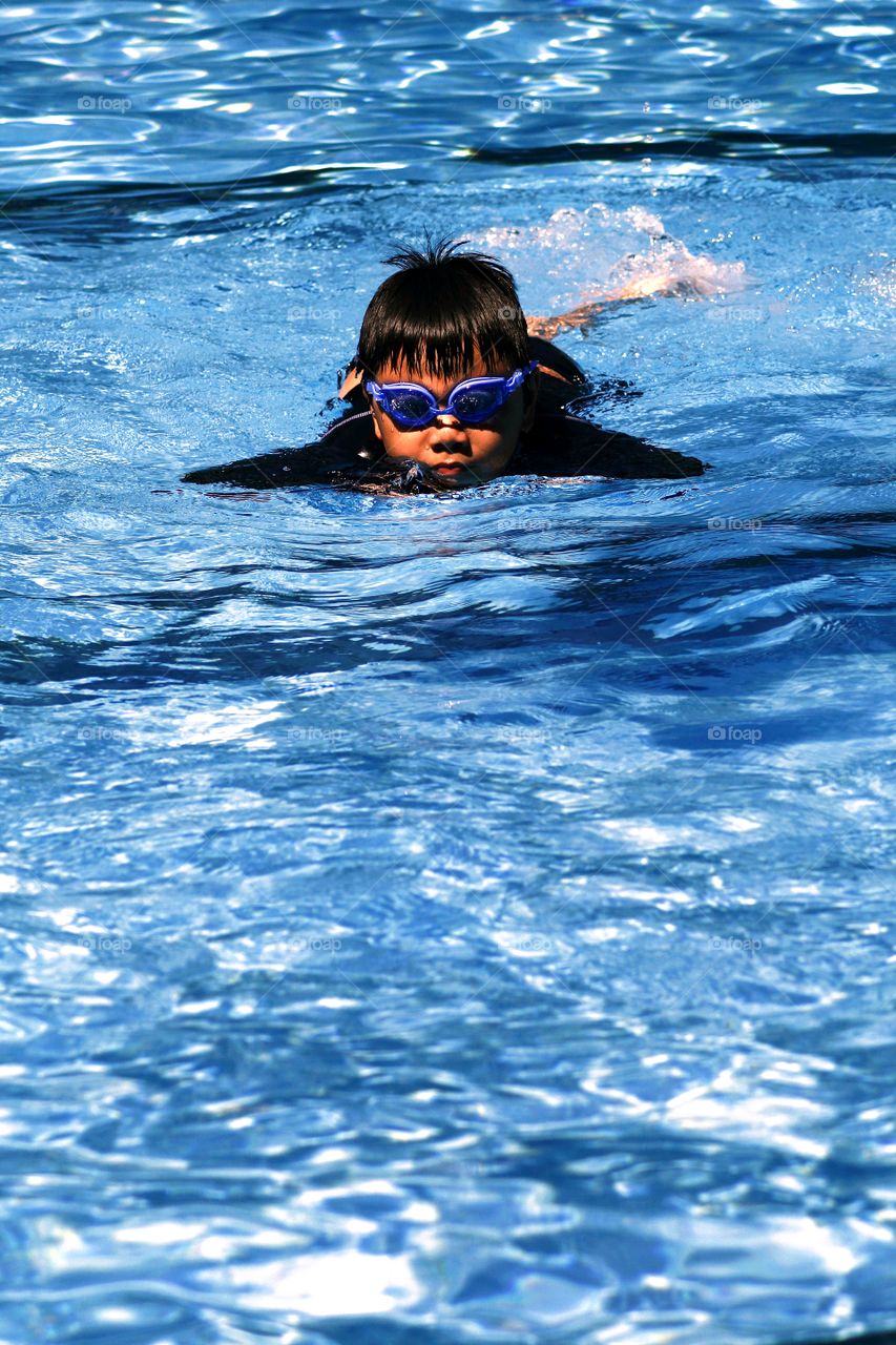 young kid swimming in a swimming pool