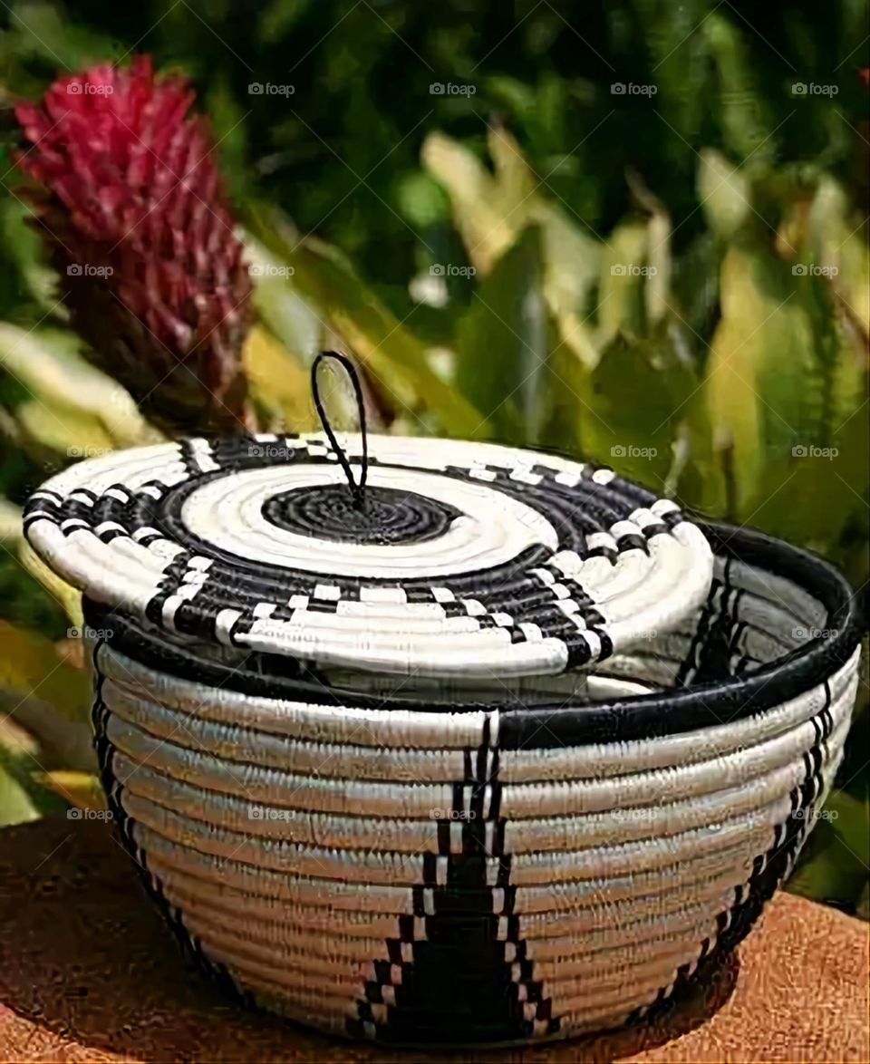 The image shows a group of hand -made dishes of wicker, decorated with colored embroideries with beautiful floral shapes, and is elegantly displayed in a warm corner that combines heritage and beauty, which gives the place an artistic spirit and attr